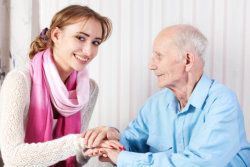 Senior man with her caregiver at home. Grandfather, daughter.